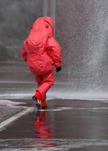 πυροσβέστης με κόκκινο προστατευτικό εξοπλισμό έναντι βιολογικών κινδύνων - Φωτογραφία, εικόνα