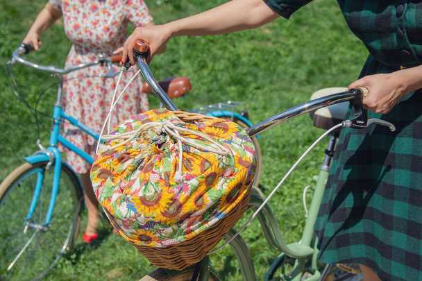 Frau mit Retro-Fahrrädern mit Korb für ein Picknick. Jahrgang - Foto, Bild