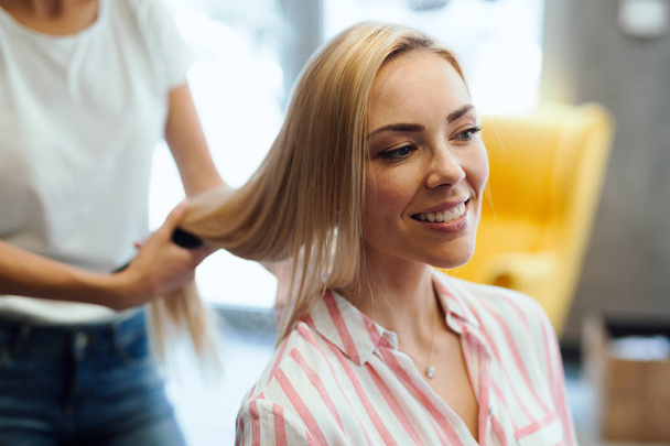 Portrait of a happy woman at the hair salon - Photo, image