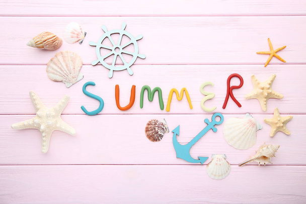 Inscription Summer by plasticine with seashells on pink wooden table - 写真・画像