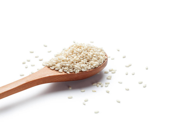 White sesame seeds in a wooden spoon on white background - Photo, Image