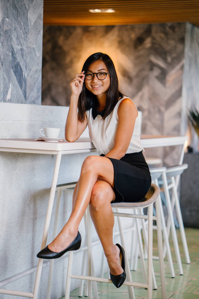 Business portrait for a young, attractive, athletic and cute Chinese Asian woman with coffee posing  in cafe - Foto, Imagem