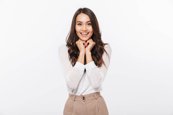 Portrait of a smiling asian businesswoman standing and looking at camera isolated over white background - Valokuva, kuva