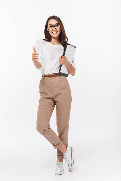 Портрет щасливої азіатської бізнес-леді, що тримає буфер обміну і показує великі пальці вгору ізольовані на білому тлі
 - Фото, зображення