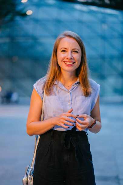 Portrait of a White Caucasian woman posing in city. She is dressed professionally in office attire and smiling  - Foto, Bild