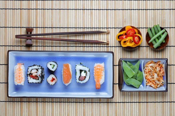 Arrangement of sushi with chopsticks, pickled vegetables and peppers - Fotoğraf, Görsel