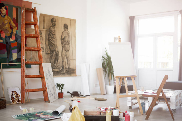 Interior of artist`s atelier. Paintings and painting material all around. - Photo, Image