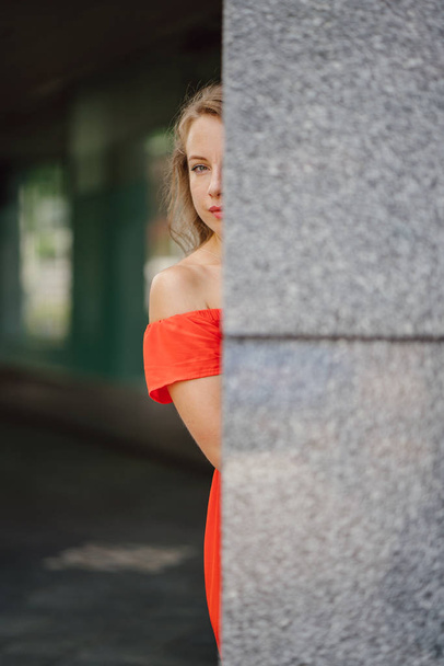 Nuoren, viehättävän eurooppalaisen naisen muotokuva oranssissa kesämekossa. Hän on vaalea vihreät silmät ja hymyilee luottavaisesti
. - Valokuva, kuva
