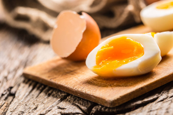 Close-up boiled or raw chicken eggs on wooden board. - Фото, зображення