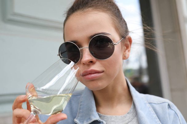 Portrait of a beautiful girl with a glass of white wine. - Valokuva, kuva