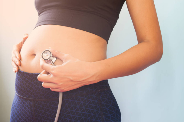 Raskaus nainen jooga vaatteet tilalla stetoskooppi, Terve raskaana oleva nainen
 - Valokuva, kuva