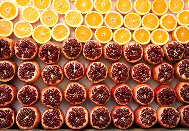 το Top view φρέσκα καθαρισμένα ρόδια και κομμένα τα πορτοκάλια - Φωτογραφία, εικόνα