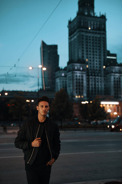 Portrait of stylish man on night city background pose to camera - 写真・画像
