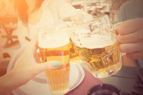 Glass of beer in hands close up shot - Фото, изображение