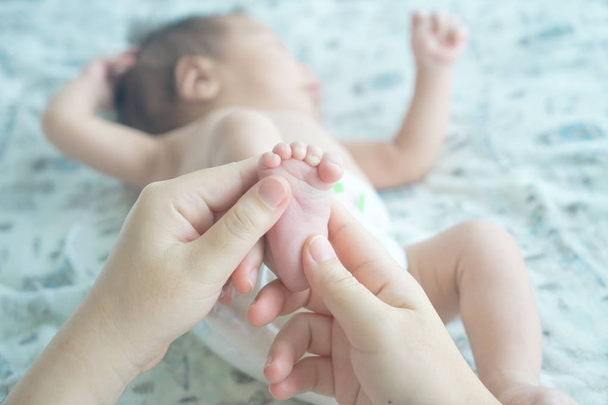 Mother makes massage for a baby boy on the his foot - Foto, Imagen