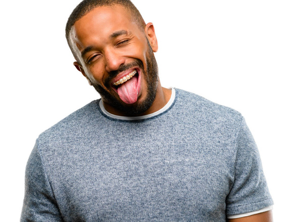 African american man with beard sticking out tongue at camera at sign of disobedience, protest and disrespect isolated over white background - Zdjęcie, obraz