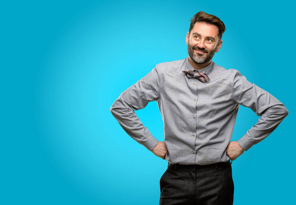 Middle age man, with beard and bow tie confident and happy with a big natural smile laughing - Photo, Image