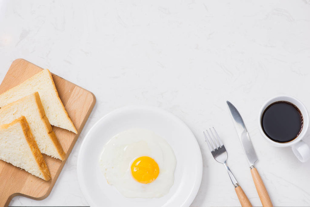 Αυγά τηγανιτά με τοστ και καφέ στο τραπέζι - Φωτογραφία, εικόνα