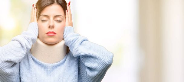 Young injured woman wearing neck brace collar covering ears ignoring annoying loud noise, plugs ears to avoid hearing sound. Noisy music is a problem. - Photo, Image