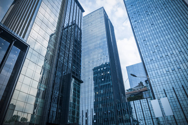 青空に対するビジネス地区の近代的な高層ビルの下のビュー - 写真・画像