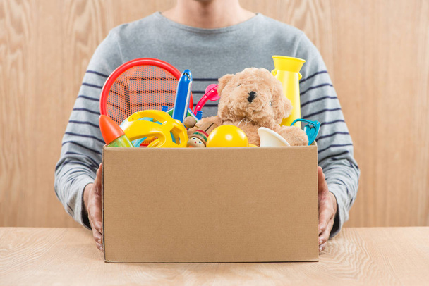 Erkek gönüllü bağış kutusu oyuncakları ile tutarak, kırpma - Fotoğraf, Görsel