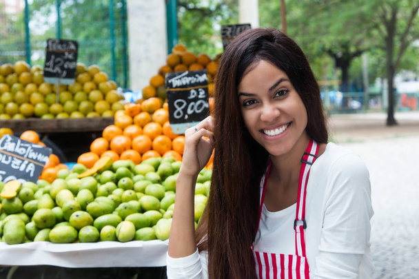 Latin american woman selling fruits outdoors at farmers market - Zdjęcie, obraz
