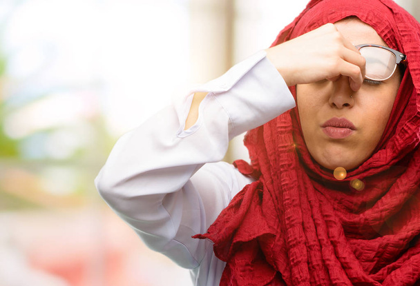 Giovane araba indossa hijab con espressione assonnata, essendo troppo lavorato e stanco, strofina il naso a causa della stanchezza
 - Foto, immagini