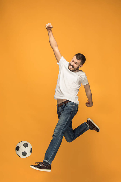 The young man as soccer football player kicking the ball at studio - Foto, afbeelding