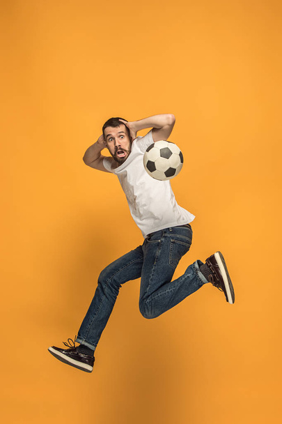 The young man as soccer football player kicking the ball at studio - Foto, Bild