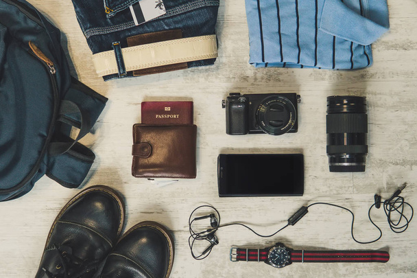 Cestovní koncept - boty, džíny, chytrý telefon fotoaparát, watch na bílém vintage pozadí. Poplatky mužů na dovolené. - Fotografie, Obrázek