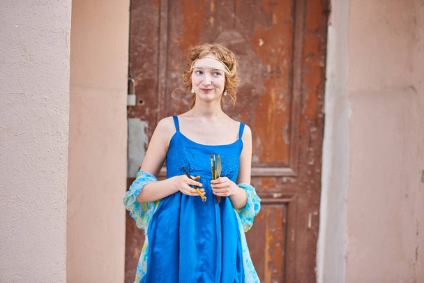 Hermosa artista chica en la calle en vestido azul, con borla en la mano
 - Foto, Imagen