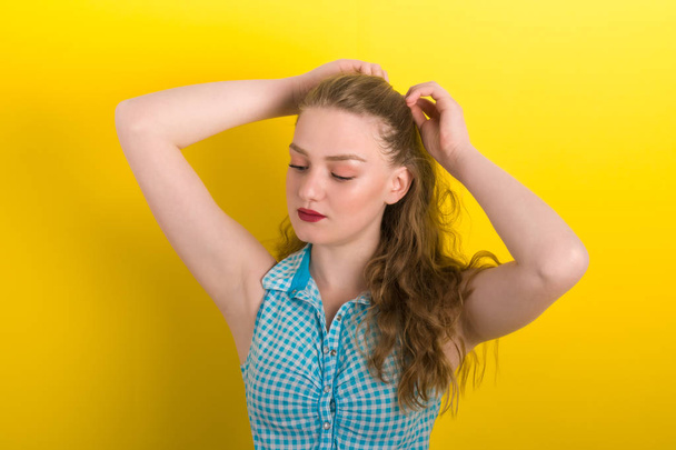 beautiful blonde in blue and white cotton shirt on a yellow background. - Fotografie, Obrázek