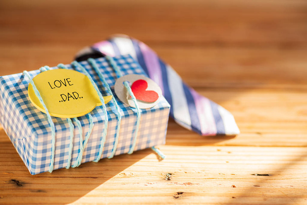 Boldog Apák napja koncepció. színes nyakkendő és ajándék doboz fából készült asztal háttér, szeretet apa címkével. - Fotó, kép