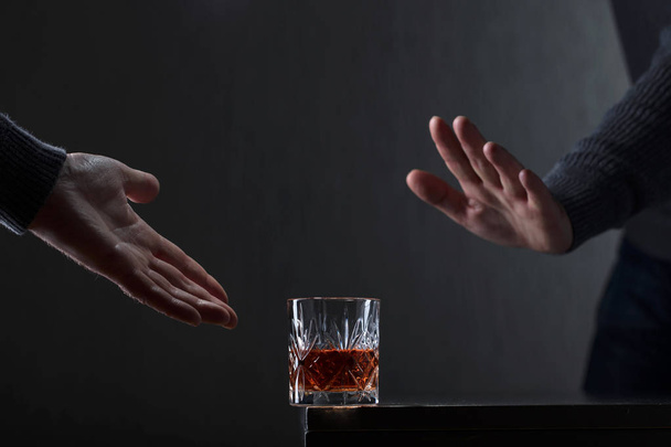 Mann mit Geste lehnt Alkohol ab konzeptionelles Bild zum Thema Alkoholismus. Kopierraum für Ihren Text. - Foto, Bild