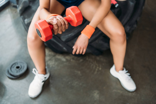 cropped image of sportswoman in wristbands doing exercise with dumbbell at gym  - Foto, Bild