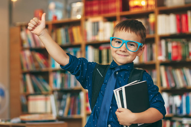 Rapaz feliz na biblioteca
 - Foto, Imagem