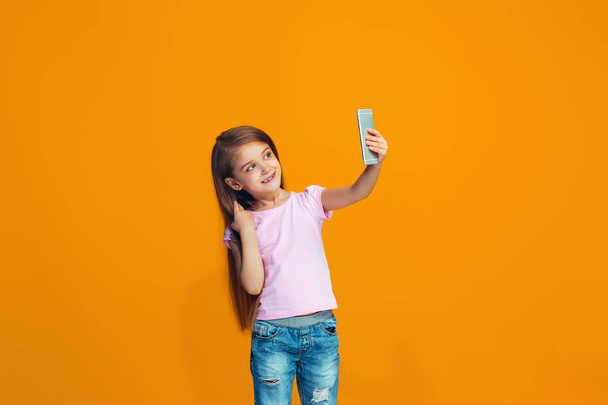 The happy teen girl standing and smiling with phone - Photo, Image