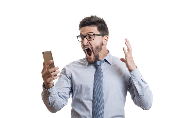 Young amazed businessperson with beard yelling and looking on display of his smartphone - Foto, imagen