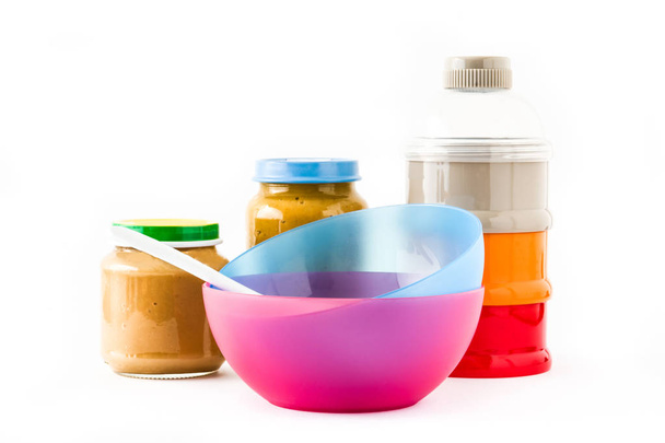 Nourriture pour bébé : Pot avec purée de fruits et bols colorés isolés sur fond blanc
 - Photo, image