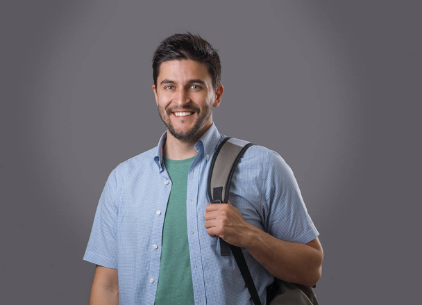 Портрет молодого усміхненого студента з щетиною і рюкзаком на плечі
 - Фото, зображення