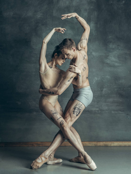 The young modern ballet dancers posing on gray studio background - Valokuva, kuva