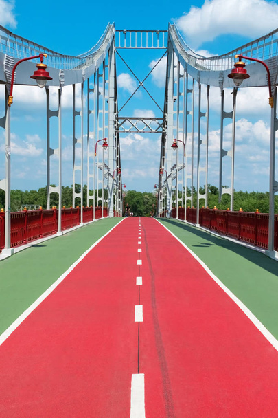 Κόκκινο ποδήλατο διαδρομή στη γέφυρα πάνω από τον ποταμό - Φωτογραφία, εικόνα
