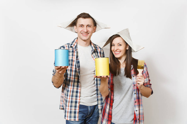 Young happy woman, man in casual clothes holding paint brush, empty paint tin can with copy space. Couple isolated on white background. Instruments for renovation apartment room. Repair home concept - Photo, Image