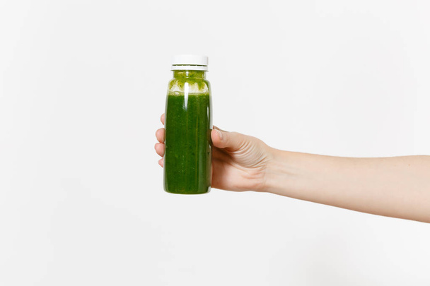Lähikuva naisten tilalla kädessä vihreä detox smoothies pullossa eristetty valkoisella pohjalla. Oikea ravitsemus, kasvisjuoma, terveelliset elämäntavat, ruokavalio käsite. Kopiotilan mainosalue
 - Valokuva, kuva