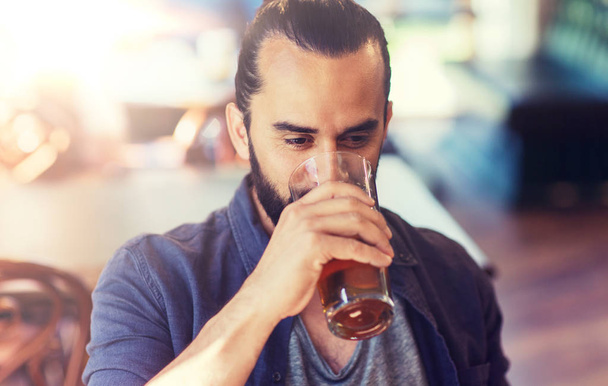 happy man drinking beer at bar or pub - Foto, afbeelding