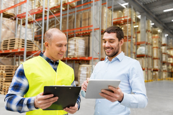 worker and businessman with tablet pc at warehouse - Foto, Imagen