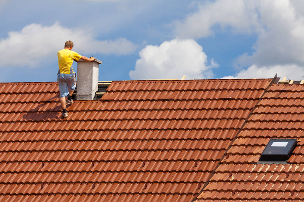 hombre trabajando en el techo de un edificio - Foto, Imagen