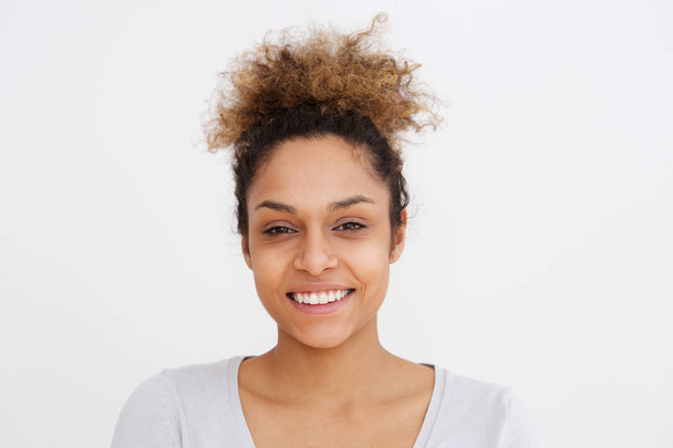 Nahaufnahme Porträt einer jungen Afroamerikanerin, die vor weißem Hintergrund lächelt - Foto, Bild