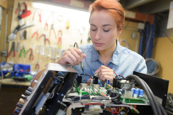 young woman technician repair electronics device toned image - Foto, afbeelding