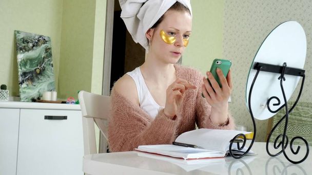 attractive business woman applying cosmetic facial spots at home, talking on the phone - Photo, Image